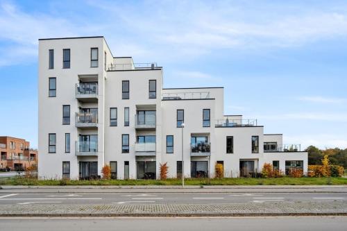 a white building on the side of a street at Central og rolig lejlighed med gratis parkering in Hedehusene