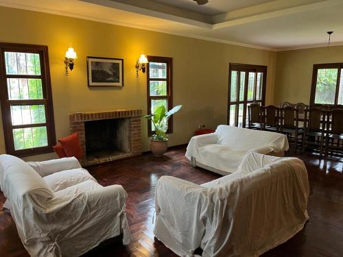 a living room with white couches and a fireplace at La Arboleda in Corrientes