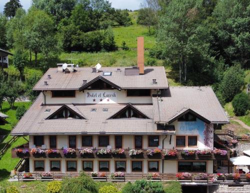 a building with a tile roof on a hill at Hotel El Laresh in Moena
