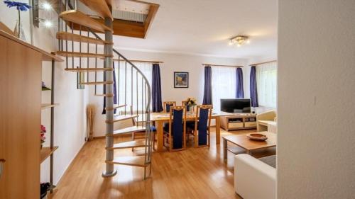 una sala de estar y comedor con escalera de caracol en Ferienwohnung Daun, en Schalkenmehren