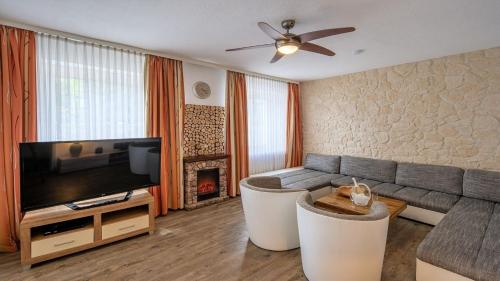a living room with a couch and a television at Ferienhaus City Ferienhaus Daun in Daun