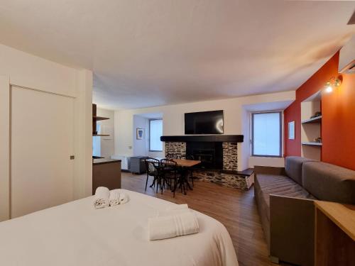 a room with two beds and a living room with a fireplace at Porto 03 in Albosaggia