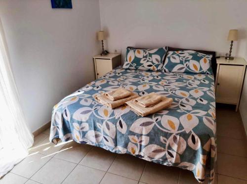 a bedroom with a bed with a floral comforter at The Town House - Mojacar in Mojácar