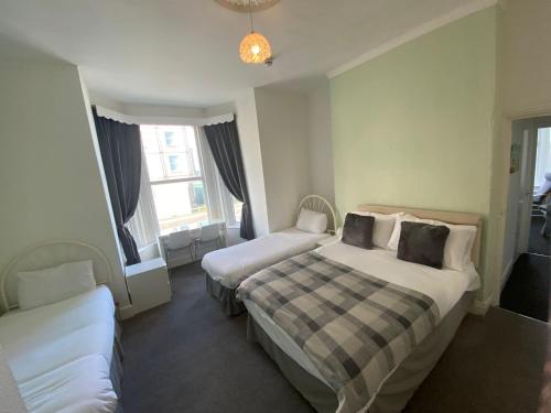 a hotel room with two beds and a couch at Farina No2, Sea view apartment sleeping 4 guests in Bridlington