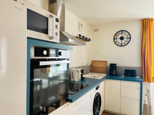 une cuisine avec une cuisinière et un micro-ondes dans l'établissement Market Appart 44m2 - 1 chambre - près du Marché, à La Rochelle