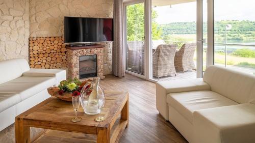 a living room with a couch and a fireplace at Ferienwohnung Maarpanorama in Schalkenmehren am See in Schalkenmehren