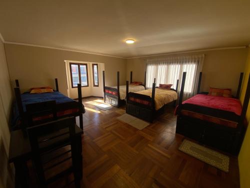 a bedroom with two beds and a wooden floor at Raven La Paz in La Paz
