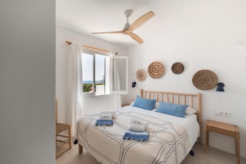 a bedroom with a bed with a ceiling fan at BiniVento- Lovely villa with pool near the beach in Binibeca