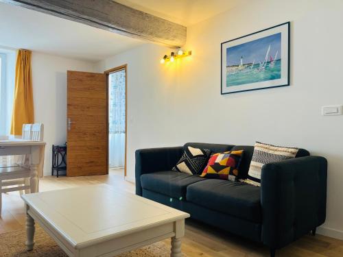 un salon avec un canapé et une table basse dans l'établissement Market Appart 44m2 - 1 chambre - près du Marché, à La Rochelle