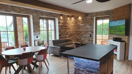 a living room with a table and a couch at Ferienwohnung Luxus 5 Sterne Ferienwohnung - Chalet Seenähe in Schalkenmehren