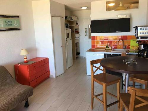 a kitchen with a table and a small kitchen with a table and chairs at Seafront studio in Algajola