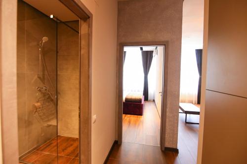 a glass shower in a room with a bedroom at Casa Iacob ApartHotel in Braşov