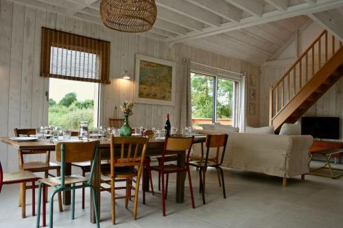 une salle à manger avec une table, des chaises et un canapé dans l'établissement La maison dans la carrière, à Regnéville-sur-Mer