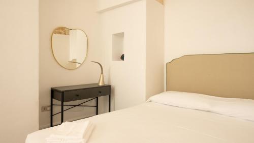 a white bedroom with a bed and a mirror at Chicca's Rooms in Lecce