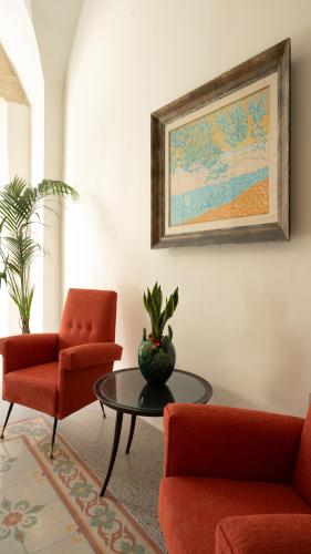 a living room with a table and two chairs and a painting at Chicca's Rooms in Lecce