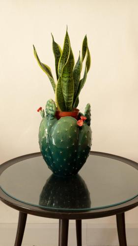 a green vase with a plant in it on a table at Chicca's Rooms in Lecce