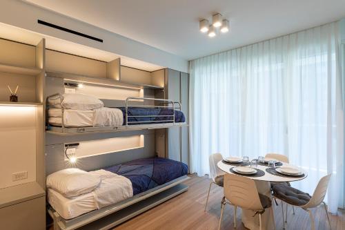 ミラノにあるTorre Milano Luxury Suite Gym-Pool&Rooftopの二段ベッドとテーブルと椅子のある部屋