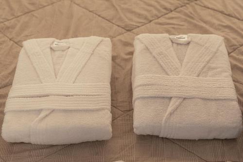 ミラノにあるTorre Milano Luxury Suite Gym-Pool&Rooftopのベッドの上にタオル2枚が備わります。