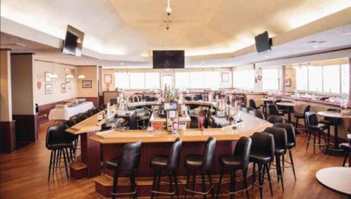a restaurant with a long bar with black chairs at Charming, Restful Getaway in Bushkill