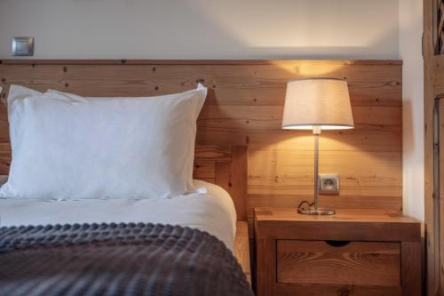 a bedroom with a bed and a lamp on a table at ALPA appartements - Champagny-en-Vanoise in Champagny-en-Vanoise
