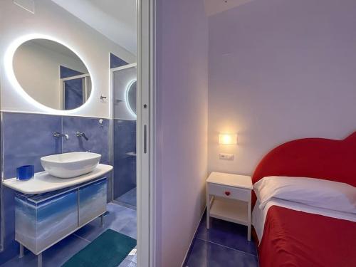 a bathroom with a bed and a sink and a mirror at Amalfi Rooms Duoglio Beach -amazing seaview in Amalfi
