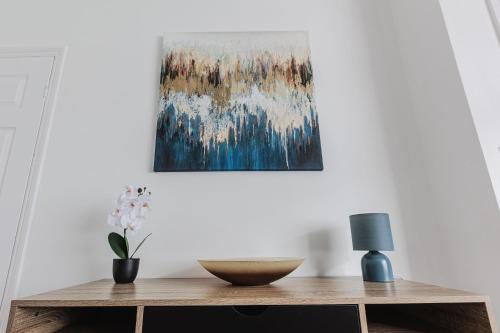 a living room with a table with a painting on the wall at Carlisle House in Seaton Carew