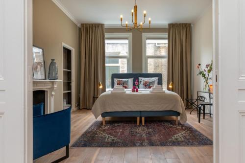 a bedroom with a blue bed and a fireplace at Het Herenhuis Middelburg in Middelburg