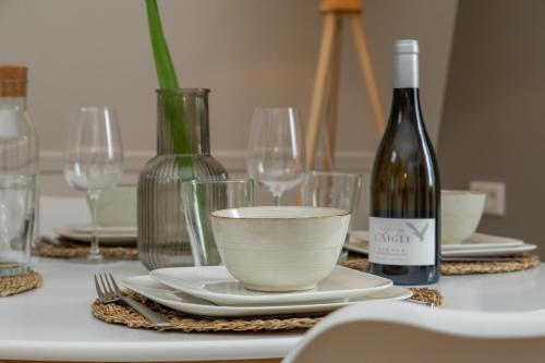 a white table with a bottle of wine and glasses at Het Herenhuis Middelburg in Middelburg