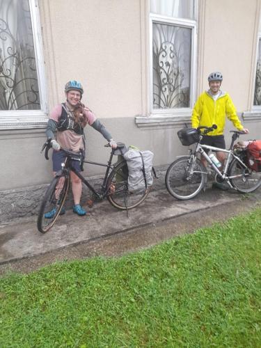 two people standing with their bikes on a sidewalk at Guest house Enguri in Jvari