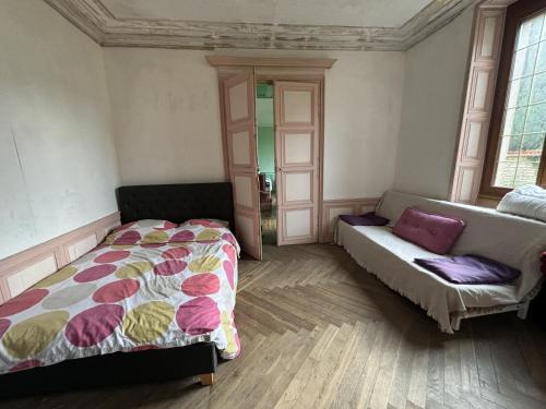 une chambre avec un lit et un canapé dans l'établissement Le Petit Saint Vorles, à Châtillon-sur-Seine