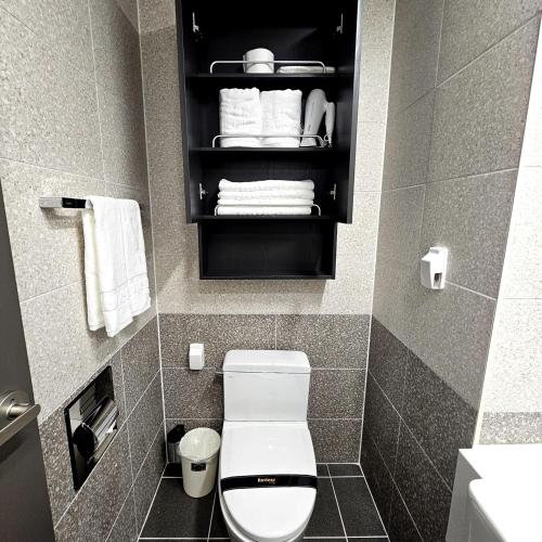 a small bathroom with a toilet and towels at 라비앙즈-Raviens-Elliy's Room in Busan