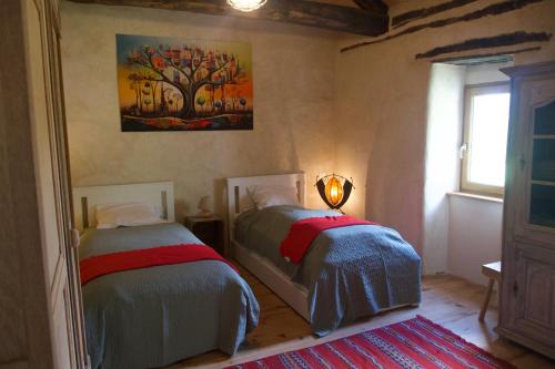 une chambre avec deux lits et un tableau au mur dans l'établissement Les IRIS des Rieux, à Sallelles