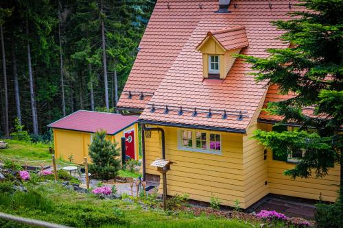 a small yellow house with a red roof at Sonnenhäusle - Natur. Fernblick. Panorama-Sauna. in Sasbachwalden