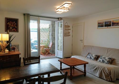 un salon avec un canapé et une table dans l'établissement Proche Lorient Location meublée confortable pour 2 personnes, à Cléguer
