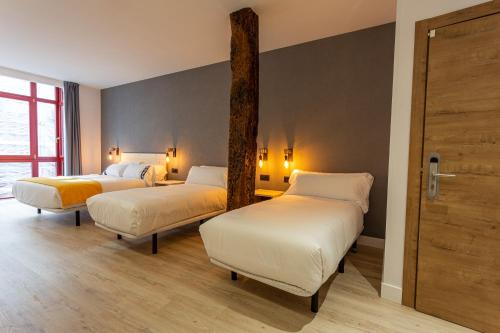 a room with two beds in a room at Casual Fuentes in Bilbao