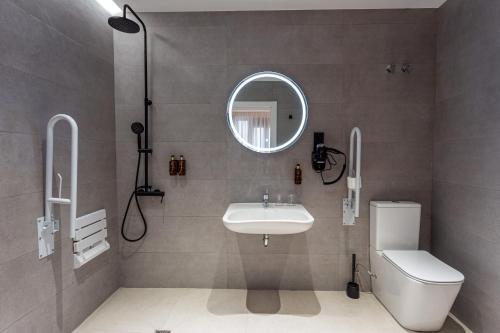 a bathroom with a sink and a toilet and a mirror at Casual Fuentes in Bilbao