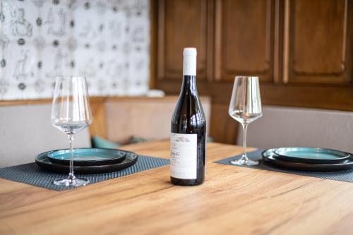 a bottle of wine sitting on a table with two glasses at Sonnenhäusle - Natur. Fernblick. Panorama-Sauna. in Sasbachwalden