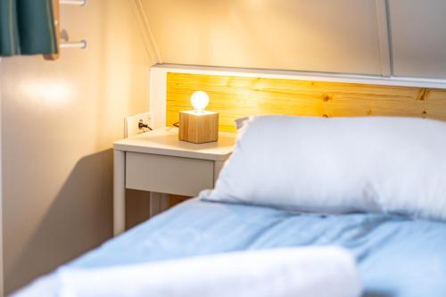 a bedroom with a bed and a nightstand with a lamp at Sonnenhäusle - Natur. Fernblick. Panorama-Sauna. in Sasbachwalden