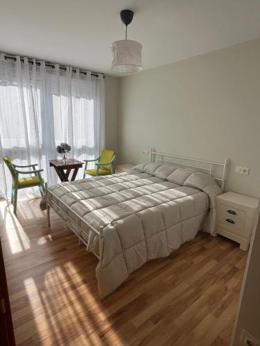 a bedroom with a large bed and a table and chairs at Fonte da Horta in Arteixo