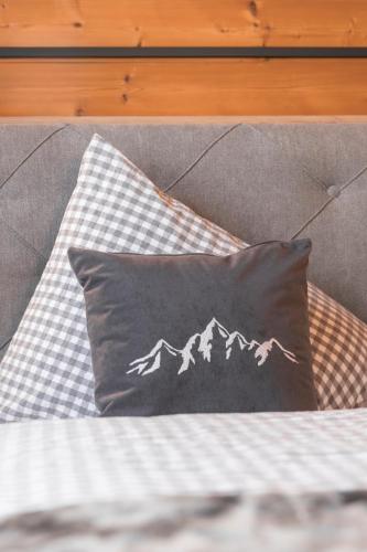 a black and white pillow on a bed at Apart Schneider in Ischgl