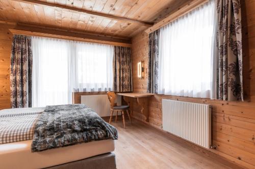 a bedroom with a bed and a desk at Apart Schneider in Ischgl