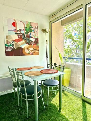 une salle à manger avec une table et des chaises et une fenêtre dans l'établissement Appartement douillet et confortable, à Caluire-et-Cuire