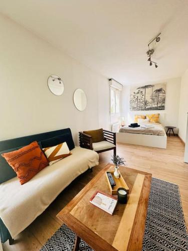 un salon avec un canapé et un lit dans l'établissement Appartement douillet et confortable, à Caluire-et-Cuire
