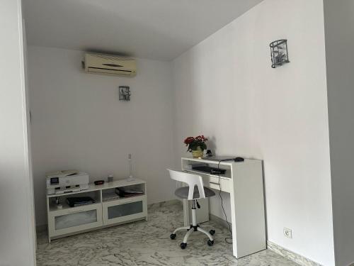 Cette chambre blanche dispose d'un bureau et d'une chaise. dans l'établissement Antibes 40m2 1-bedroom, à Juan-les-Pins