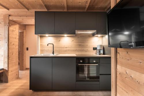 a kitchen with black cabinets and a sink at Apart Schneider in Ischgl