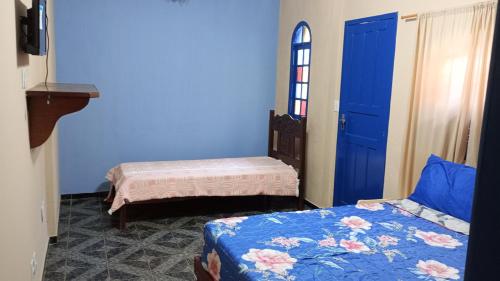 a room with two beds and a blue door at Pousada Preludio in Conservatória