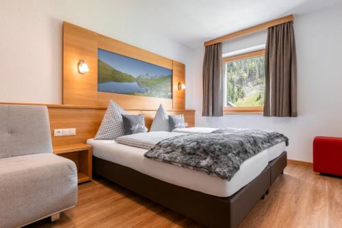 a hotel room with a bed and a window at Apart Schneider in Ischgl