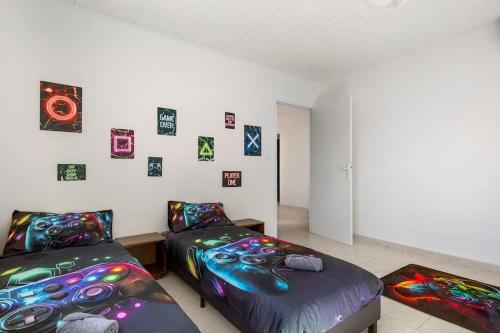- une chambre avec 2 lits et des photos sur le mur dans l'établissement Villa Familiale Gaming - 4 chambres, à Valras-Plage