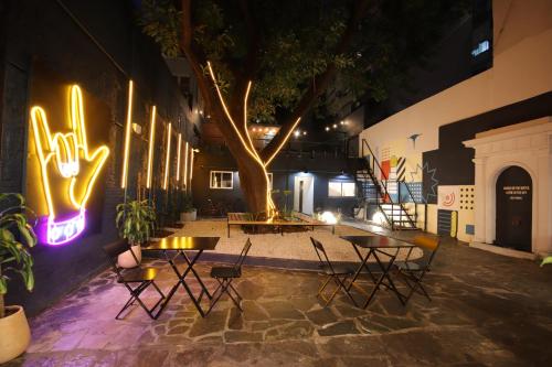 un grupo de mesas y sillas junto a un árbol en Play Hostel Garden, en Buenos Aires