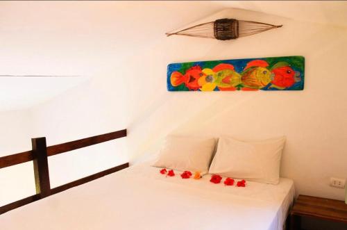 a bedroom with a bed with a painting on the wall at Pousada Maracaju in Porto De Galinhas